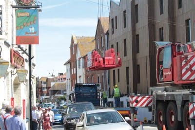The busy holiday traffic, channelled into a single lane, surges past a heavy load.
