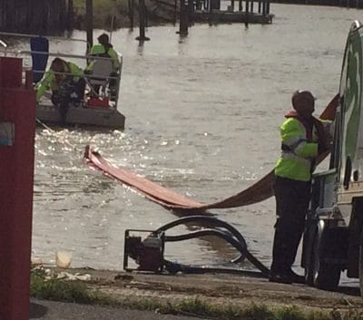 The yet-to-be-inflated boom starts its snakelike journey across the river